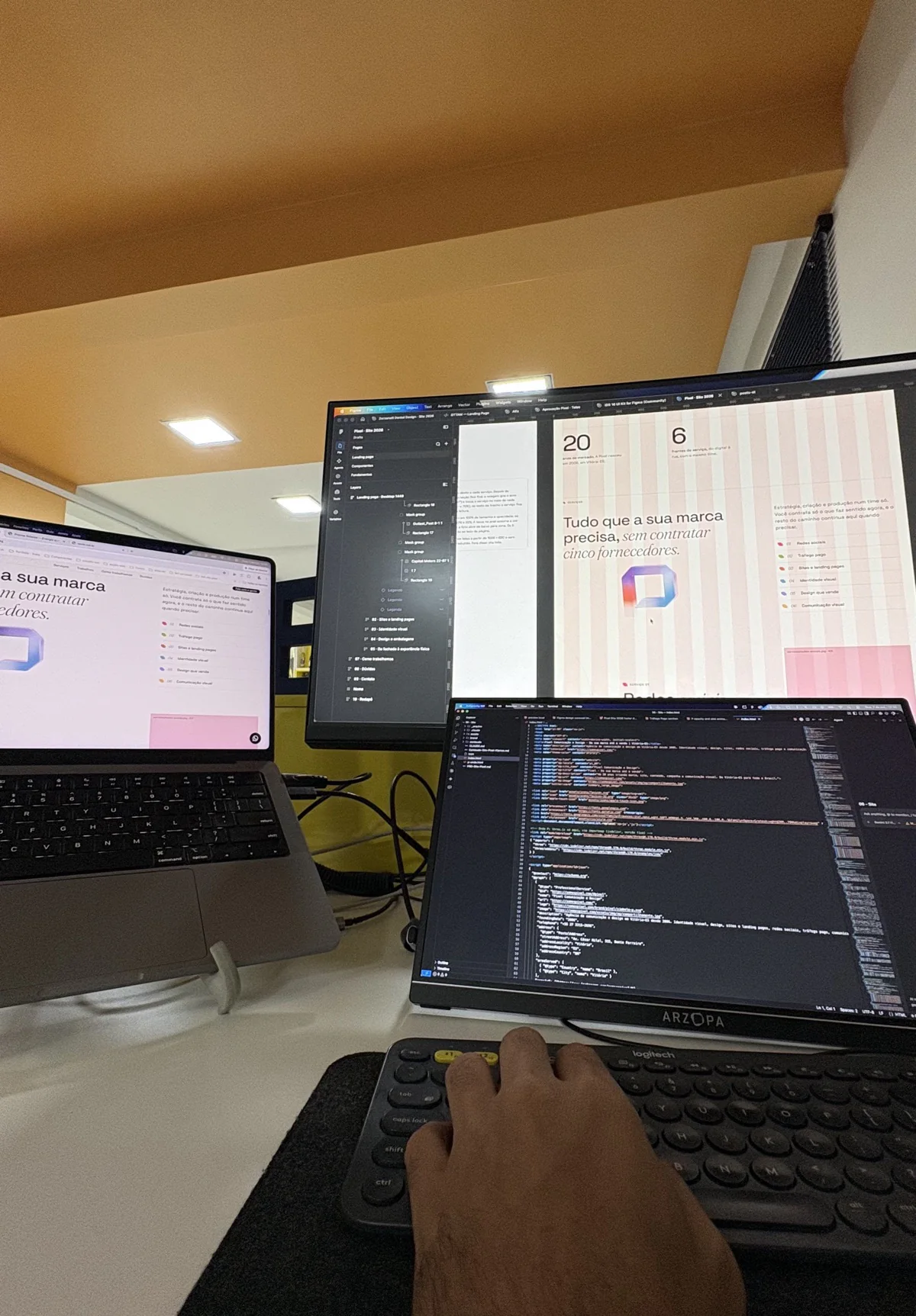 Este site em desenvolvimento na Pixel: o código no notebook e a página no monitor